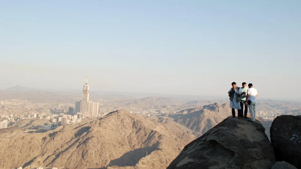 Besucher auf einem felsigen Bergrücken mit Blick über Mekka, Ziel einer Gruppenfahrt zum Jabal al-Nour