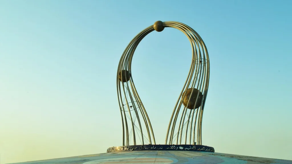 Modern arched metal sculpture on a roundabout in Jeddah under a clear sky