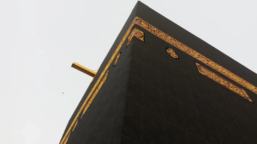 Nahaufnahme der schwarzen Kiswa mit goldbesticktem Band an der Kaaba in Mekka, gefertigt in der Kiswa-Fabrik, die Sie besuchen können