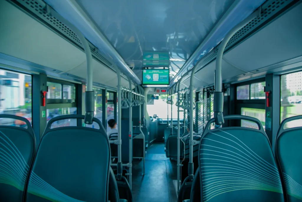 Innenraum eines Busses mit blauen Sitzen, Mittelgang und Haltegriffen – Symbolbild zum Hoteltransfer in Mekka zur Haram