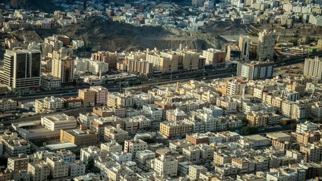Veduta aerea della Mecca con edifici fitti e montagne sullo sfondo, lo scenario di un itinerario di ziyarah
