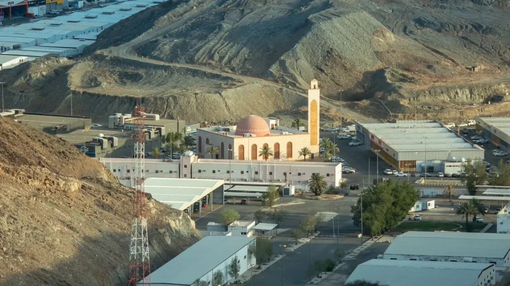Moschee zwischen felsigen Bergen am Stadtrand von Mekka von oben gesehen, ein typischer Ort für die Ziyarah in Mekka von außen