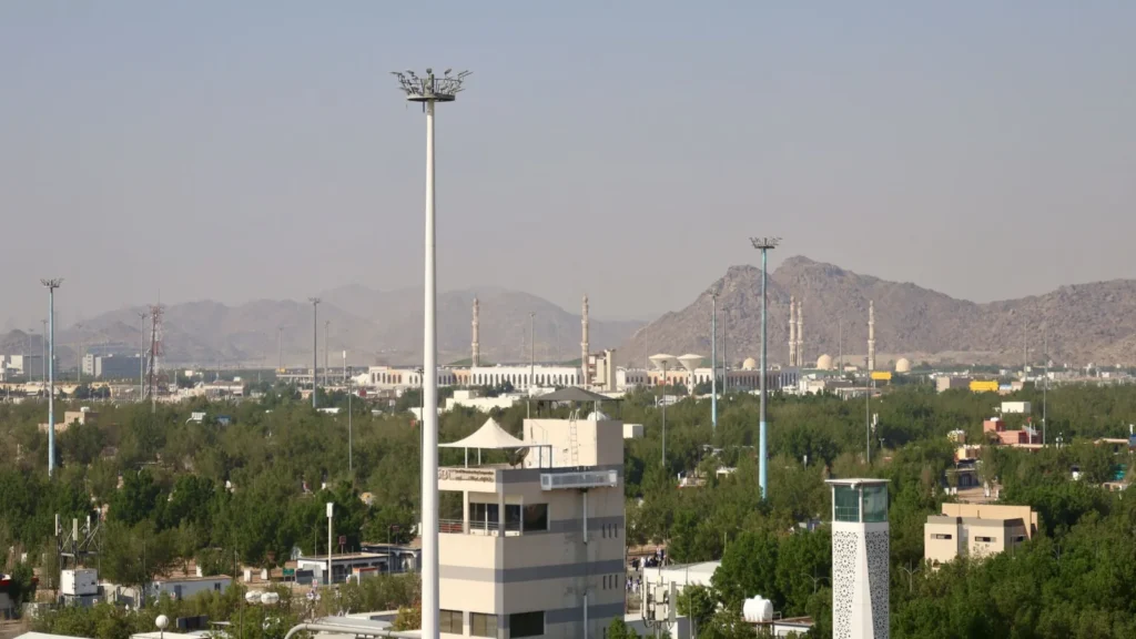 Luftaufnahme einer Moschee zwischen niedrigen Gebäuden vor kahlen Bergen in Saudi-Arabien, Ziel für ein Taxi zur Masjid al-Jiranah
