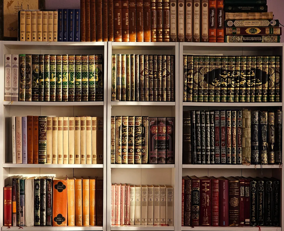 File di libri con dorsi decorati su scaffali bianchi, immagine generica per il Museo della Biografia del Profeta alla Mecca