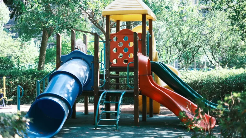 Bunter Kinderspielplatz mit Rutschen in einem sonnigen Park – Ausflugsidee für Mekka mit Kindern