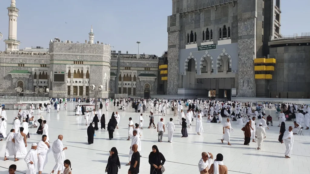 Peregrinos cruzando el patio de mármol de la Gran Mezquita, una escena previa a decidir cuándo hacer la ziyarah en La Meca